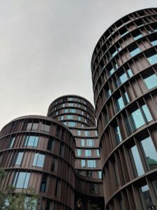"A low-angle view of the circular Axel Towers in Copenhagen, symbolizing the structured 'Systems' of policy and finance.